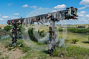 Old cowboy boots hanging on a post in Great Sandhills in Saskatchewan, Canada