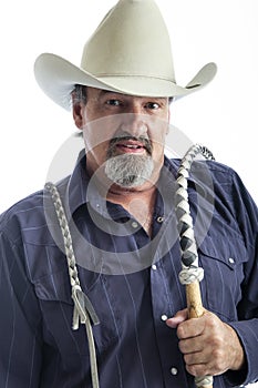 Old cowboy holding a bullwhip over his shoulder