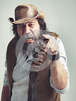 Old cowboy, point and angry face at studio, costume and pipe for western portrait looking scruffy. Senior guy, upset hat