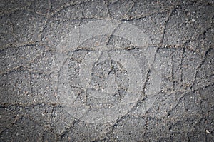 Old cracked asphalt texture or background. Vignetted. Closeup