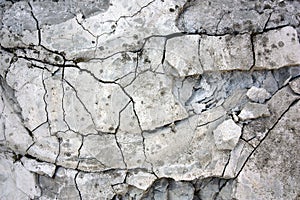 Old cracked concrete grey wall with breakaway pieces