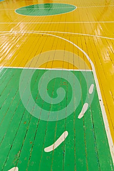 Old cracked floor of the sports hall with markings for basketball