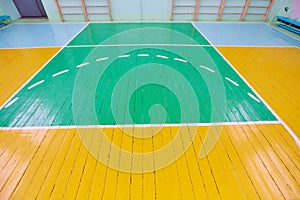 Old cracked floor of the sports hall with markings for basketball