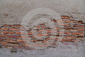 The Old Cracked Wall of a concrete building. A part of the red brick wall was abandoned wall background photo
