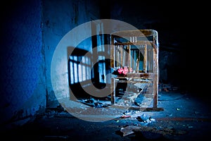 Old creepy eerie wooden baby crib in abandoned house. Horror concept photo