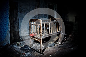 Old creepy eerie wooden baby crib in abandoned house. Horror concept