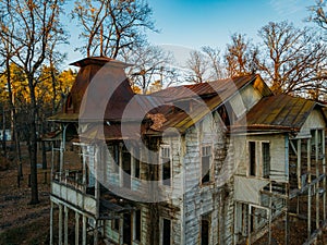 Old creepy wooden abandoned haunted mansion, aerial view