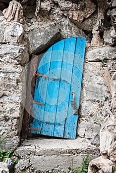 Old crooked blue wooden door in Crete Greece