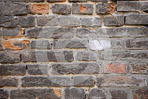 Old crumbling brick wall with cracks and chips