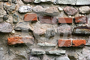 Old crumbling masonry wall with red bricks and stones.Old red brick wall, grunge background