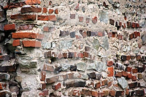 Old crumbling masonry wall with red bricks and stones.Old red brick wall, grunge background