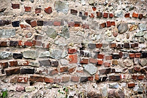 Old crumbling masonry wall with red bricks and stones.Old red brick wall, grunge background