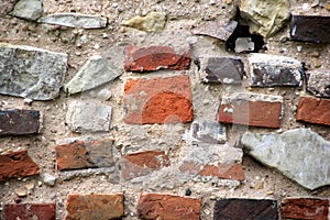 Old crumbling masonry wall with red bricks and stones.Old red brick wall, grunge background