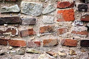 Old crumbling masonry wall with red bricks and stones.Old red brick wall, grunge background