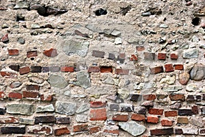 Old crumbling masonry wall with red bricks and stones.Old red brick wall, grunge background