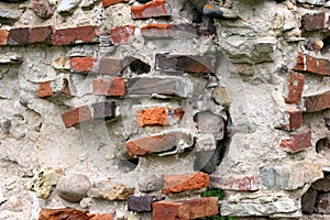 Old crumbling masonry wall with red bricks and stones.Old red brick wall, grunge background