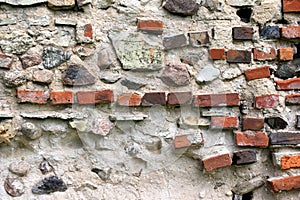 Old crumbling masonry wall with red bricks and stones.Old red brick wall, grunge background