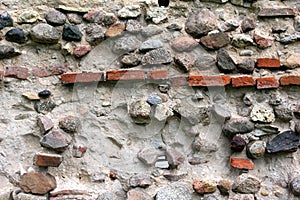 Old crumbling masonry wall with red bricks and stones.Old red brick wall, grunge background