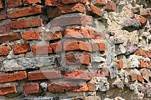 Old crumbling masonry wall with red bricks and stones.Old red brick wall, grunge background