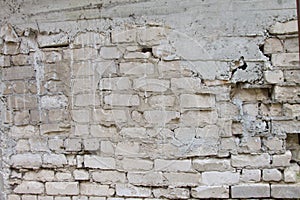 An old crumbling white brick wall