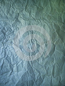 Old crumpled paper vintage texture. Rough wrinkled dark green blue color shadows sheet. Textured grunge background with