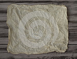 Old crumpled paper on wooden brown background