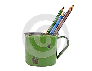 Old cup green color and pencils on white background