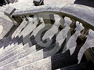 Old Curved Stone Stairs with Stone Railing and Harsh shadows, Grey, on a Sunny Day