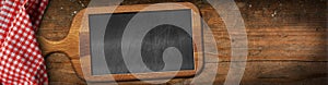 Old Cutting Board with a Blank Chalkboard on a Wooden Table