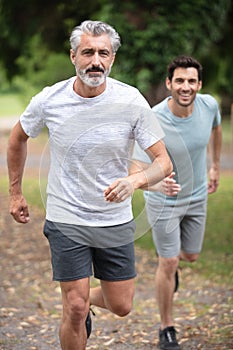 old dad and son running in countryside together