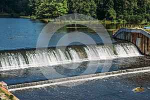 Old dam at ancient hydroelectric power station, water flows