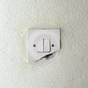 Old damage light switch on white wall