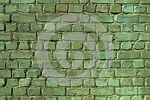 An old damaged brick wall colored in green as a background