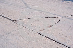 The old damaged broken concrete street background with collapsed and large crack lines texture on surface