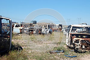 Old damaged cars in the junkyard. Car graveyard