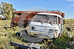 Old damaged cars in the junkyard. Car graveyard