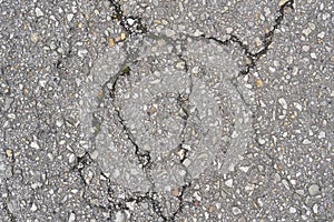 Old damaged cracked asphalt road section. Texture damage. Deterioration of the road surface