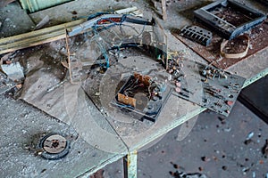 Old damaged dusty soviet electrical circuit boards on the table in abandoned factory of radio components