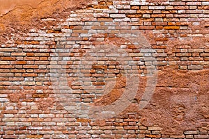 Old and damaged orange brown brick wall