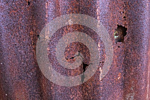 Old damaged red rusty metal wall, texture background. Detail view of old rusty corrugated metal sheet