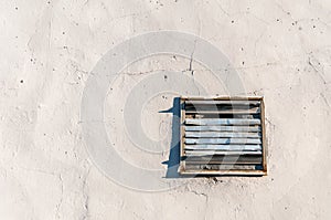 Old damaged rusty vent cover plate with grid on the wall of house or building for fresh clean air ventilation with free space