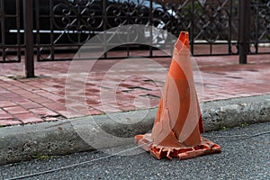 An old damaged traffic cone on the road.