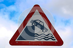 Old Danger Driving Sign at a Coastal Harbour Wall