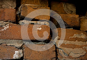 Old dark brown and red brick wall with cement slurry background, old brickwork
