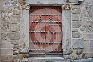 Old dark brown wooden door with two knockers in Toledo, Spain