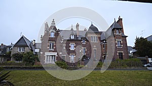 Old dark manor on background of cloudy sky. Action. Large country house in gothic style of dark brick brings fear in