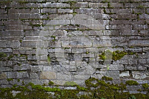 Old dark stone wall with moss as background. Wall cladding with masonry. Exterior panels. Flat lay.