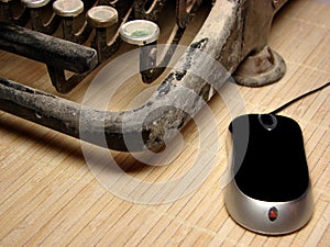 Old dark typewriter with modern mouse