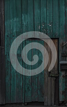 Old dark wooden rustic look barn doors. Metal hinges, and lock holders placed on the rough texture doors are very rusty