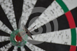 An old dartboard with a dart hit the bullseye